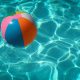colourful beach ball floating in swimming pool how to save money during summer ukds money tips blog