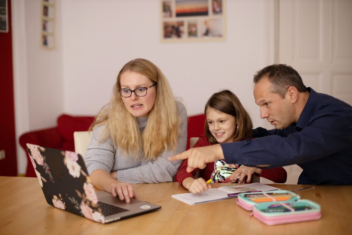 fun way to teach your kids about money ukds blog parents sat around laptop with child