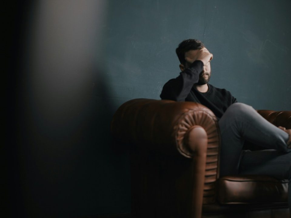 coping with financial anxiety man sits on sofa with head in hands